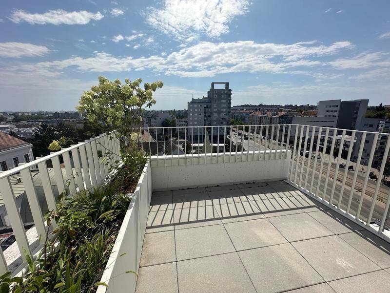 Sonnige Terrasse mit Stadtblick und integrierten Pflanzbeeten.