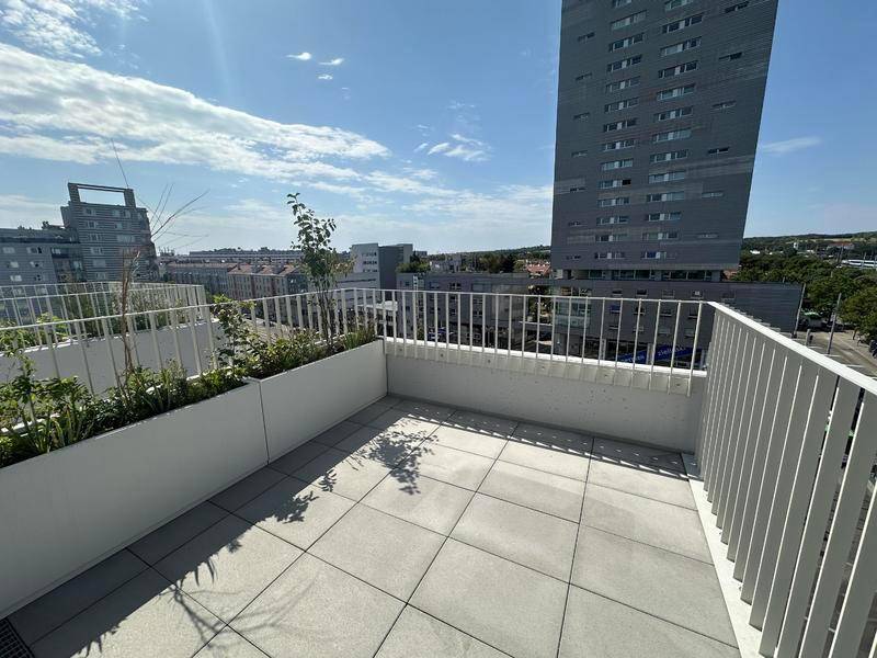 Großzügige Terrasse mit Fliesen und weitem Blick über die städtische Umgebung.