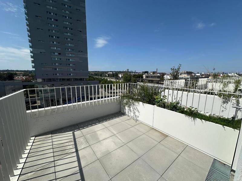Geräumige Terrasse mit Fliesenboden und Blick auf die Stadt.