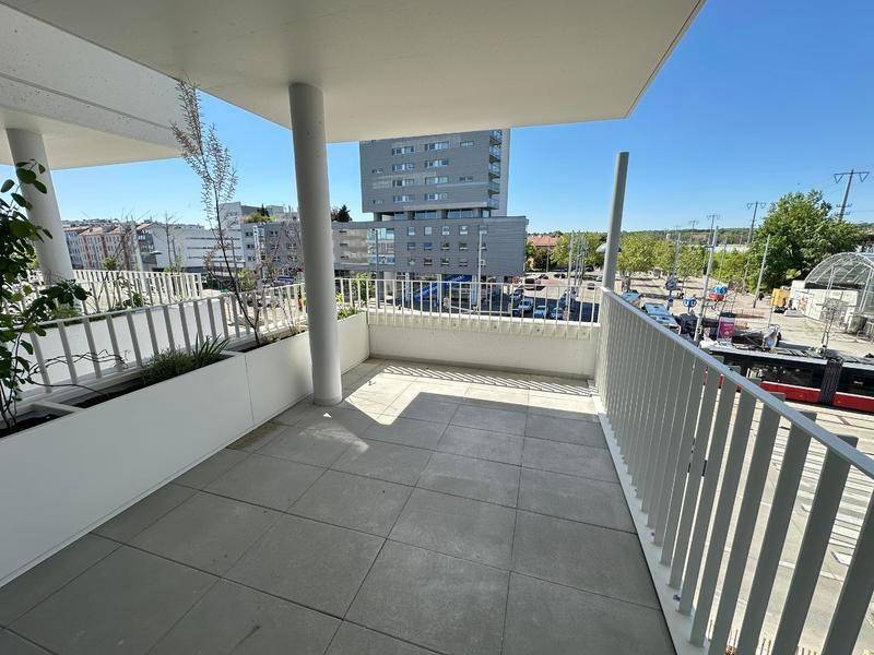 Geräumiger Balkon mit Fliesenboden und Blick auf die Stadt und die Umgebung.