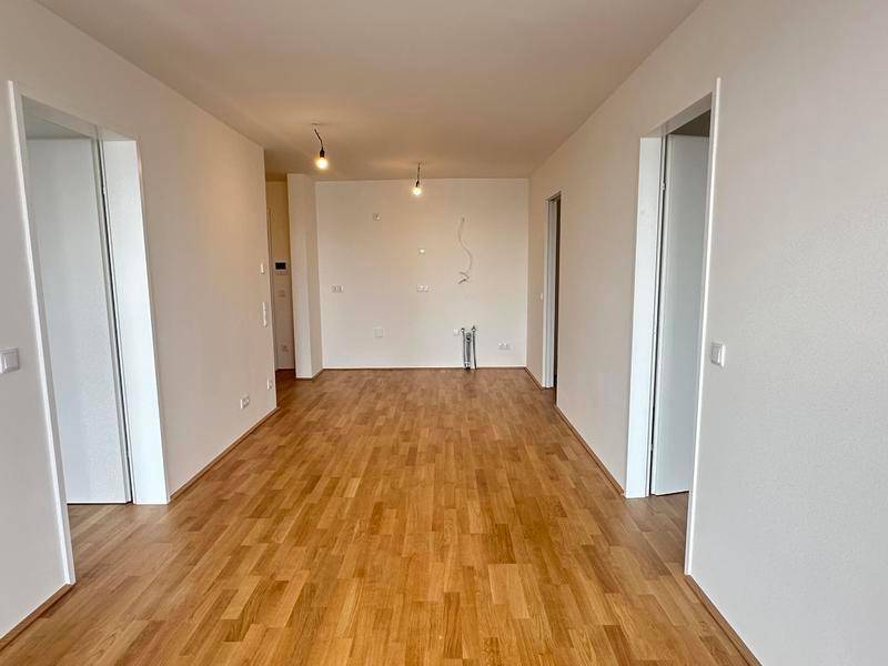 Unmöblierter Raum mit hellem Holzboden und weißen Wänden, bereit für die Einrichtung.