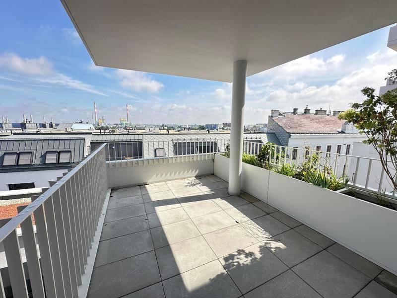 Geräumiger Balkon mit Fliesenboden und Blick auf die Stadtlandschaft und Industrieanlagen.