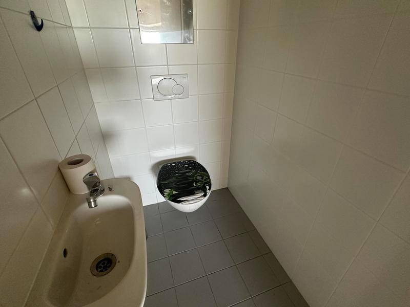 Separate Toilette mit Wand-WC, Bidet und weißen Fliesen, funktional und sauber.
