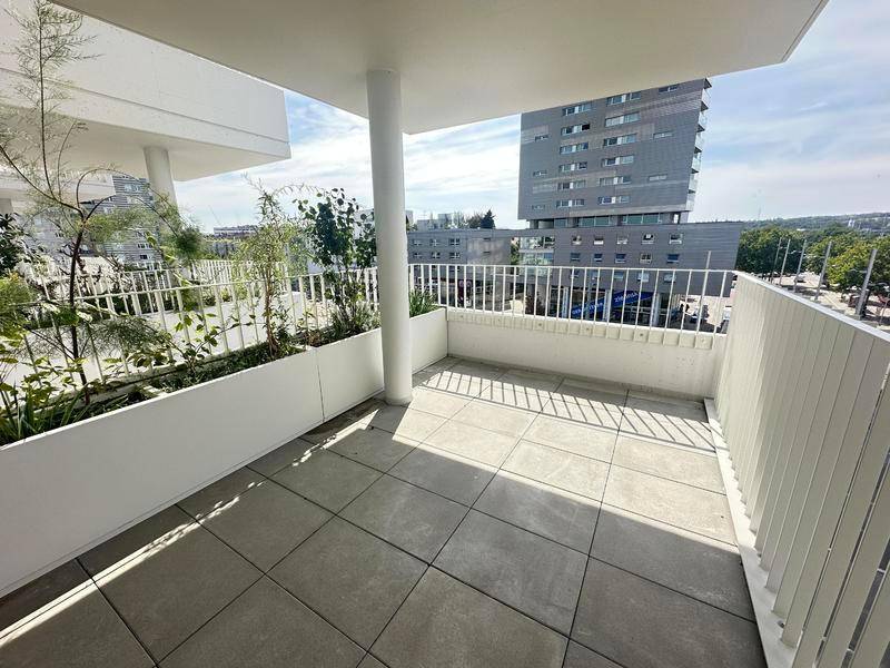 Geräumiger Balkon mit Fliesenboden und Pflanzen in modernen Pflanzgefäßen, mit Stadtblick.