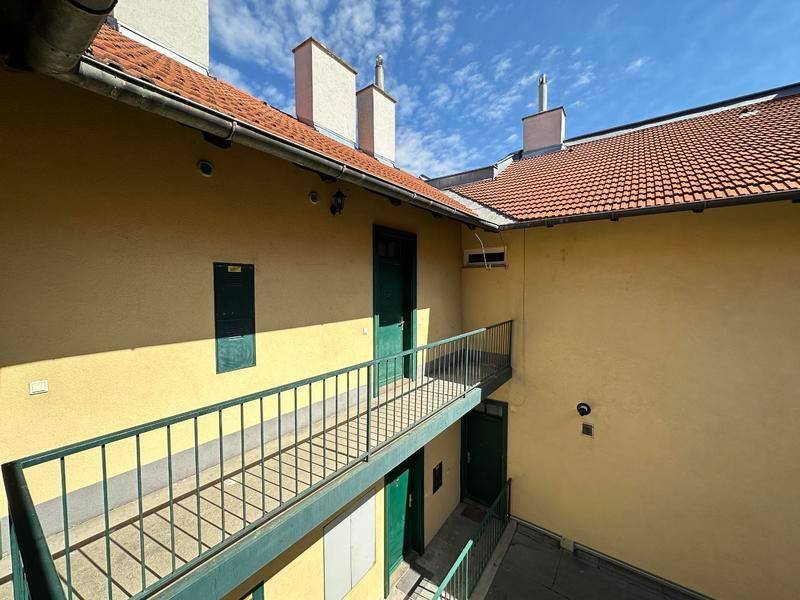 Umlaufende Balkone und Zugänge im sonnigen Innenhof des Gebäudes.