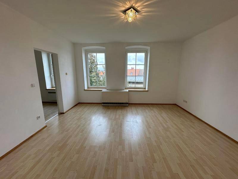 Heller Wohnbereich mit Laminatboden und dekorativer Deckenleuchte, ideal für gemütliche Abende.