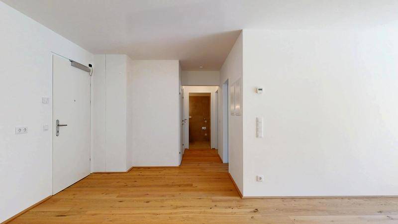 Heller Flur mit Holzboden und Zugang zu den verschiedenen Zimmern der Wohnung.