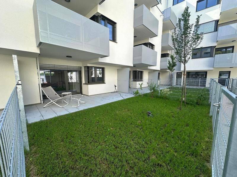 Moderne Erdgeschosswohnung mit privater Terrasse und kleinem, eingezäuntem Gartenbereich.
