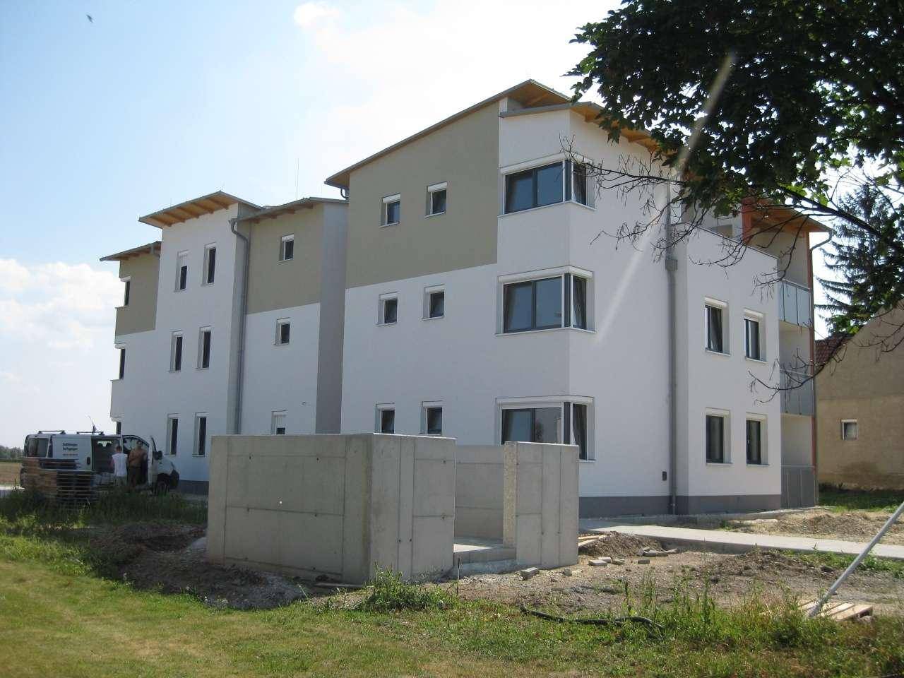 Neubau-Wohngebäude mit moderner Architektur und teilweise noch unfertiger Außenanlage.
