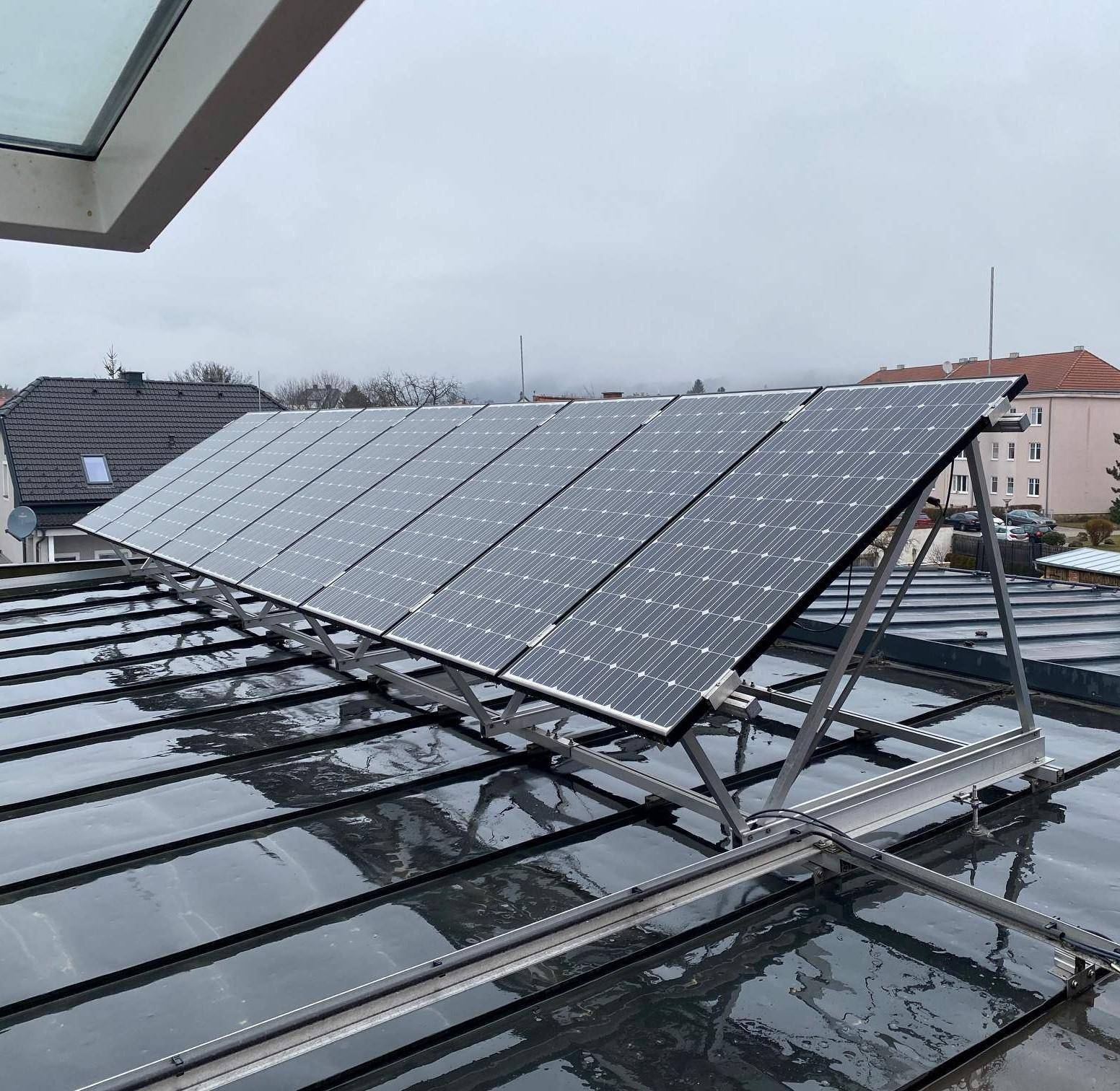 Photovoltaikanlage auf einem dunklen Metalldach zur Energiegewinnung.
