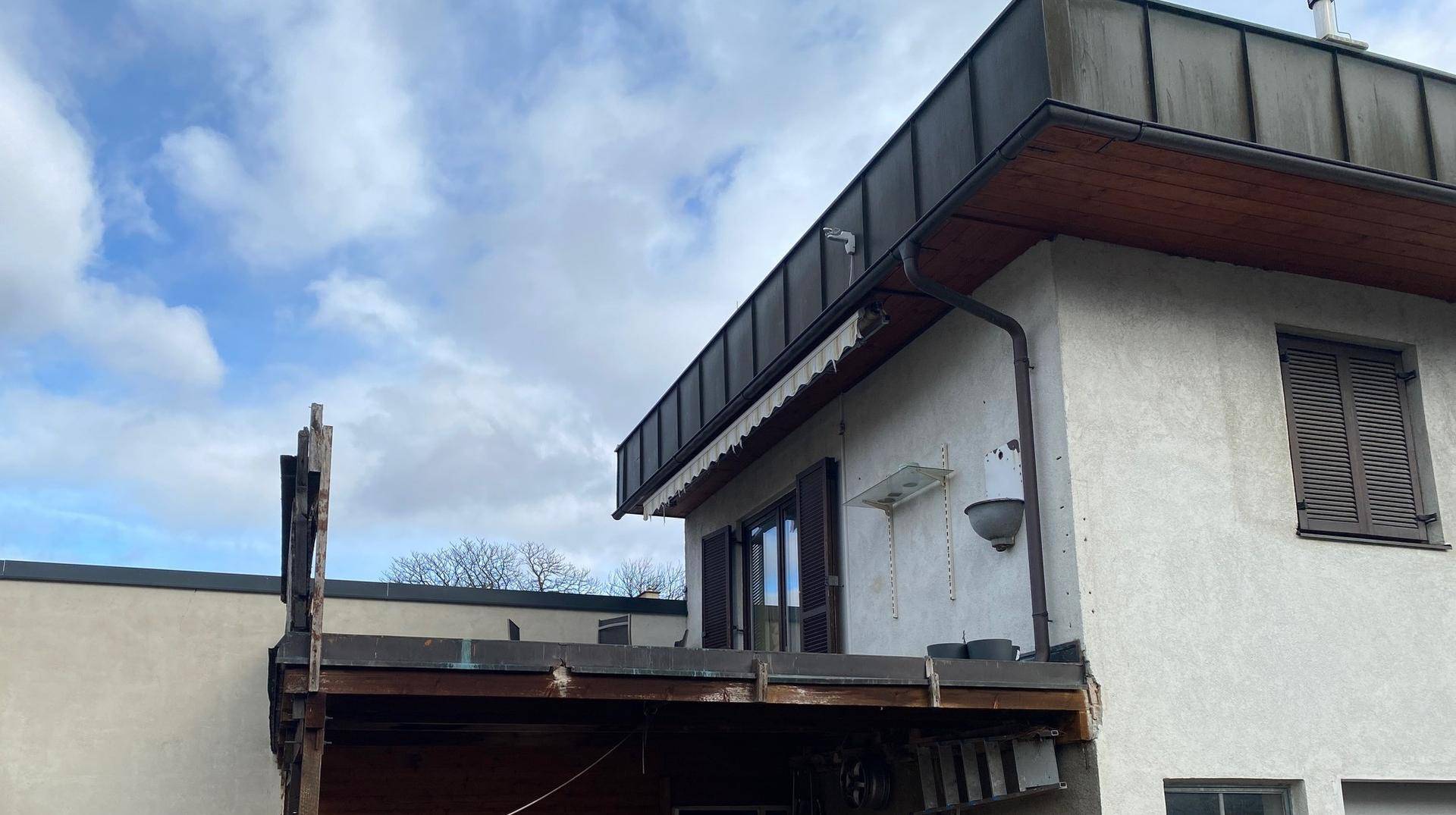 Seitenansicht des Hauses mit einem im Bau befindlichen oder abgebauten Balkonbereich.
