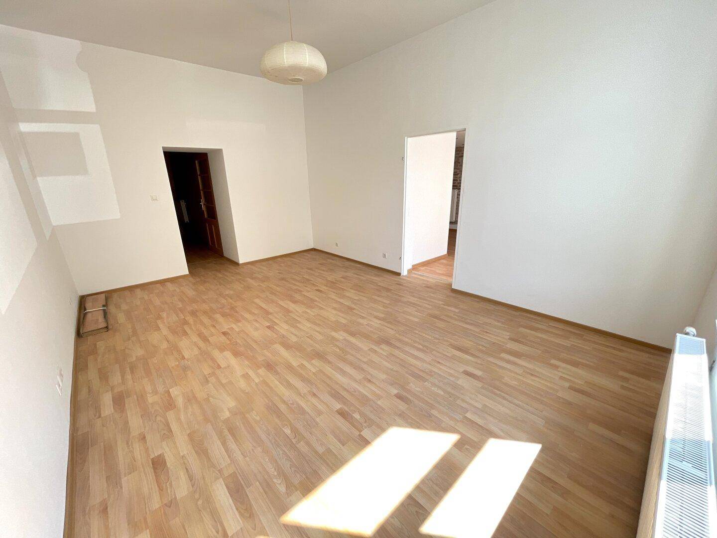 Geräumiger Innenraum mit Holzboden und weißen Wänden, bereit für individuelle Gestaltung.