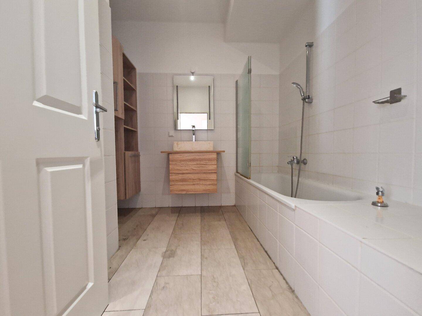Modernes Badezimmer mit Badewanne, Duschfunktion und einem stilvollen Holzwaschtisch mit Einzelwaschbecken.