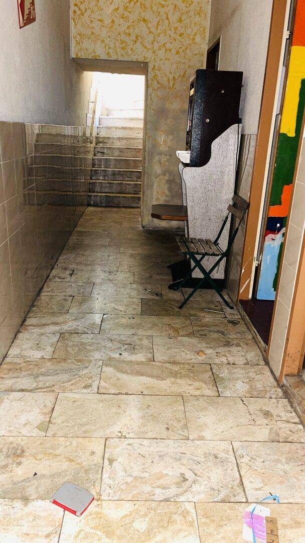 Flur mit Fliesenboden und einer Treppe, die in ein oberes Stockwerk führt.