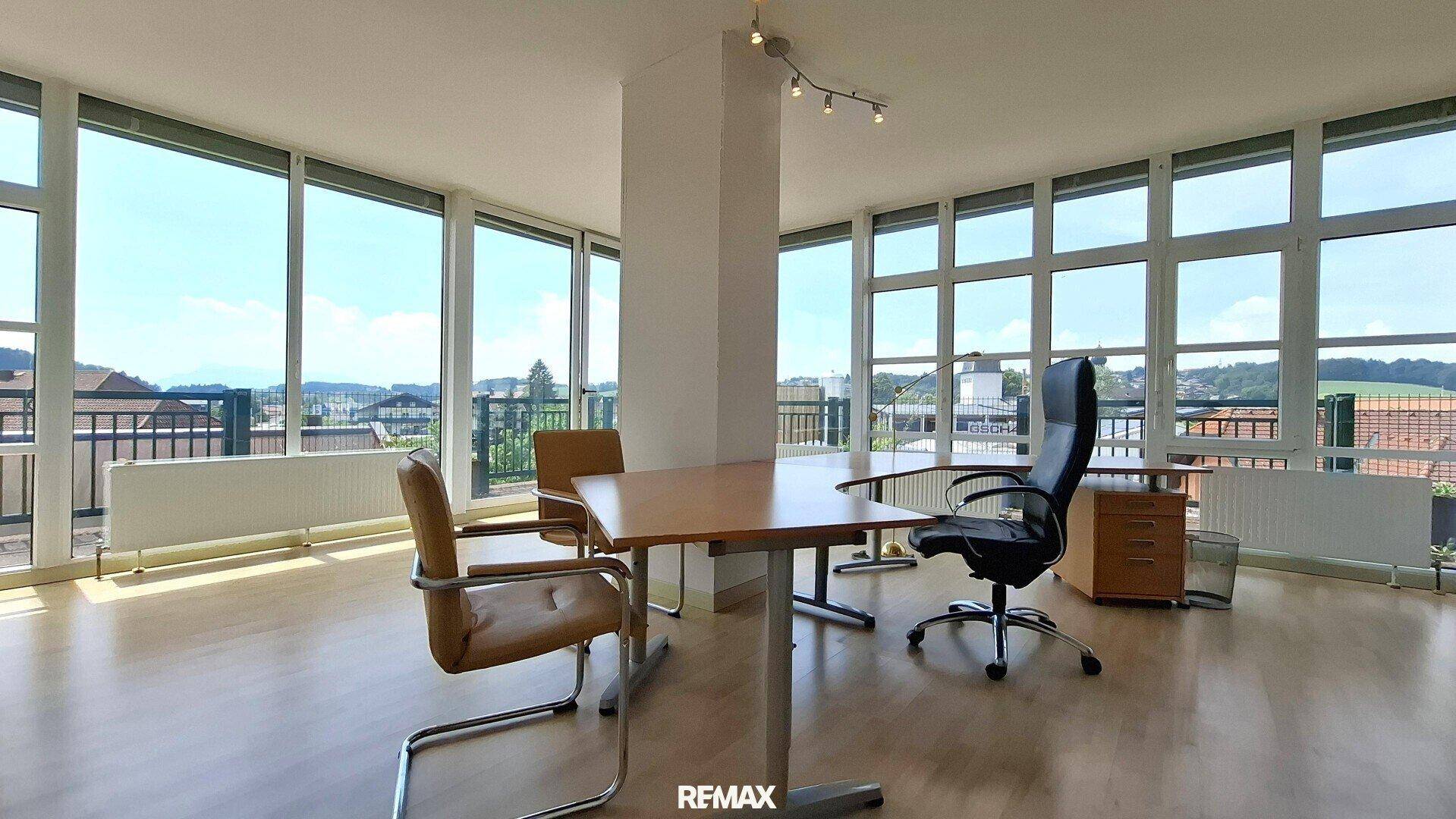 Helles Büro mit großen Fenstern, die einen weiten Blick auf die Landschaft bieten, und Holzboden.