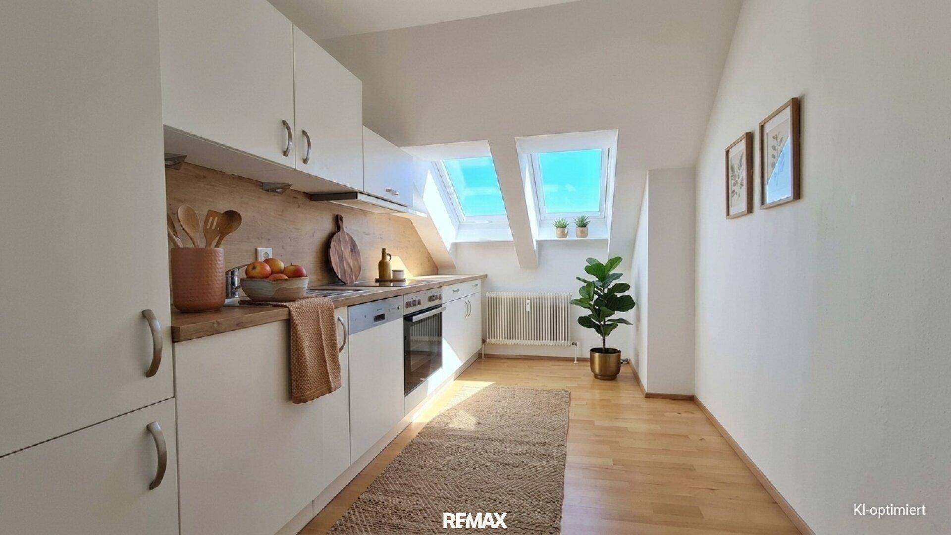Moderne Küche mit weißen Schränken, Holz-Arbeitsplatte und Dachfenstern für helle Kochmomente.