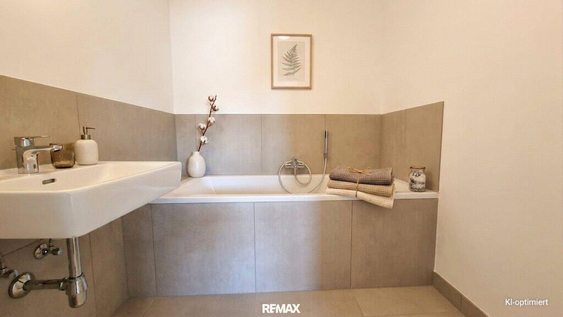 Modernes Badezimmer mit Badewanne, Waschbecken und Fliesenboden.