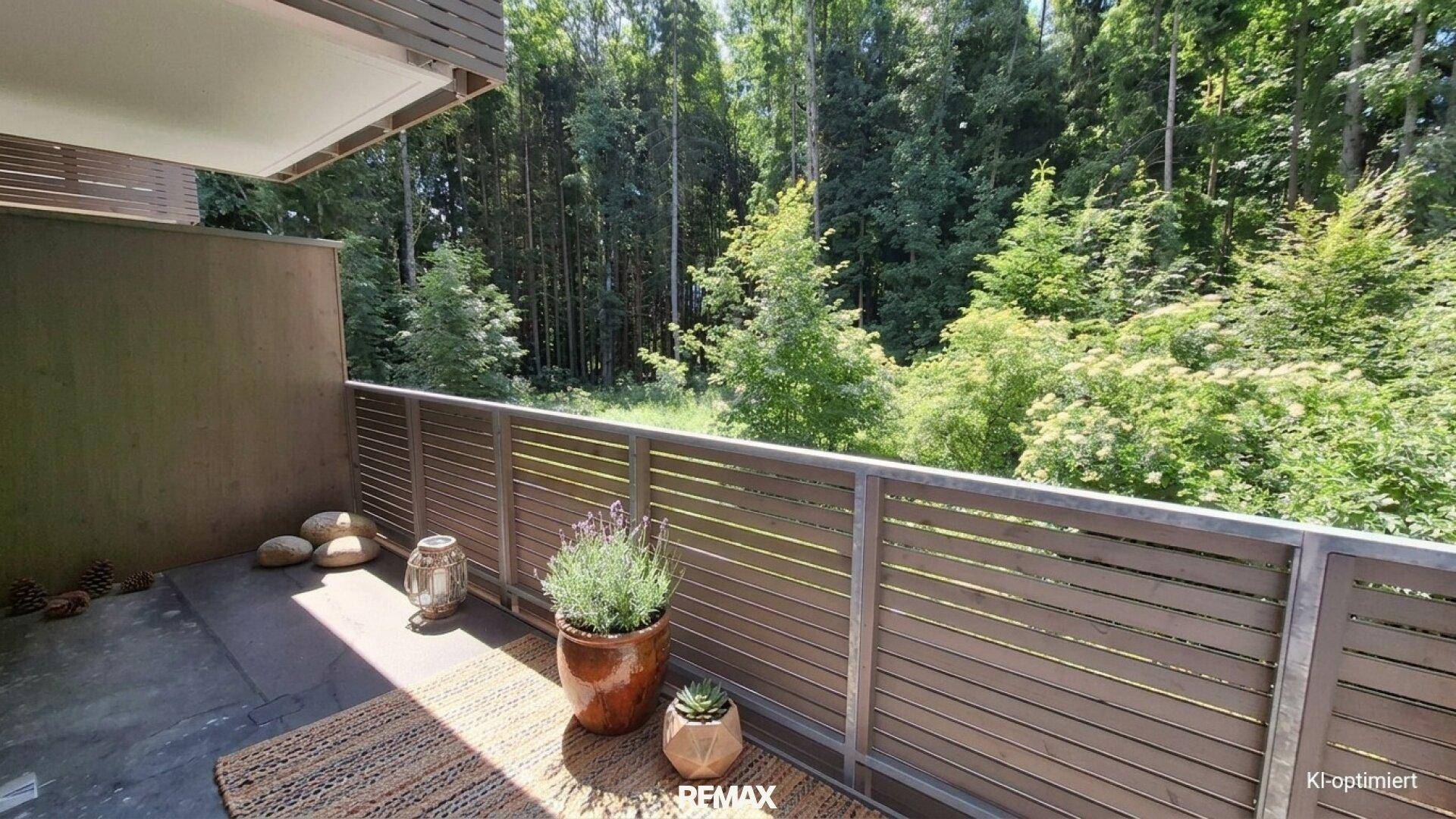 Balkon mit Holzboden und einem schönen Ausblick auf die umliegende grüne Natur.