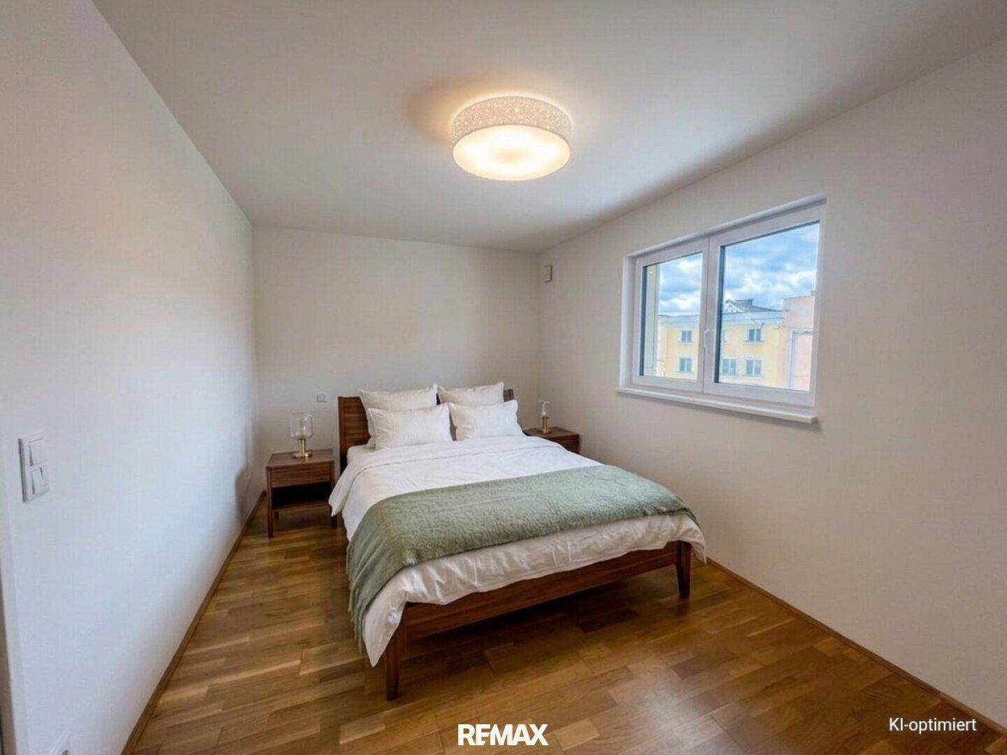 Gemütliches Schlafzimmer mit Holzbett, Parkettboden und natürlichem Lichteinfall durch das Fenster.