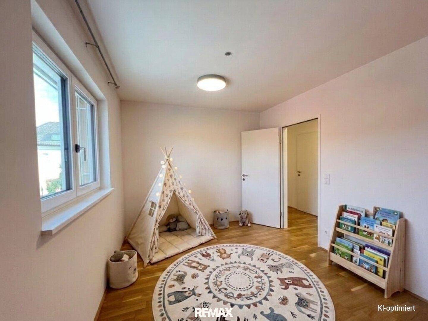 Helles Kinderzimmer mit Spielzelt, Parkettboden und einem Bücherregal, ideal zum Spielen.