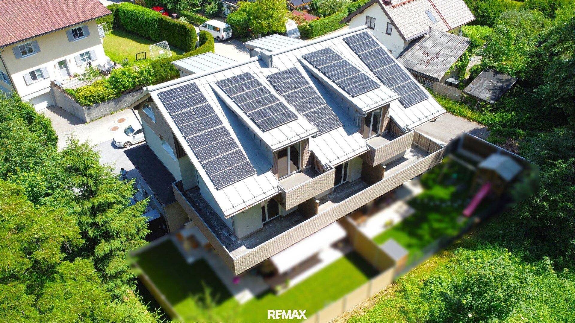 Wohnhaus aus der Vogelperspektive mit umfangreicher Photovoltaikanlage und Balkonen in ländlicher Lage.