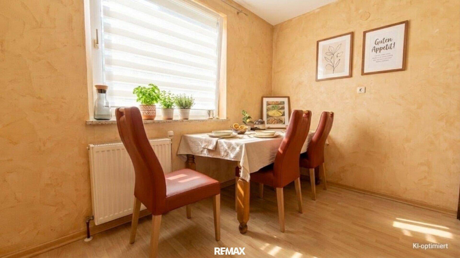 Essbereich mit Holztisch, roten Stühlen und einem Fenster, das viel Licht hereinlässt.