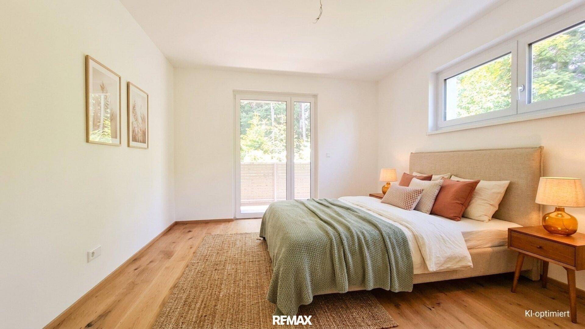 Gemütliches Schlafzimmer mit Holzboden, großem Fenster und Zugang zu einem Balkon.