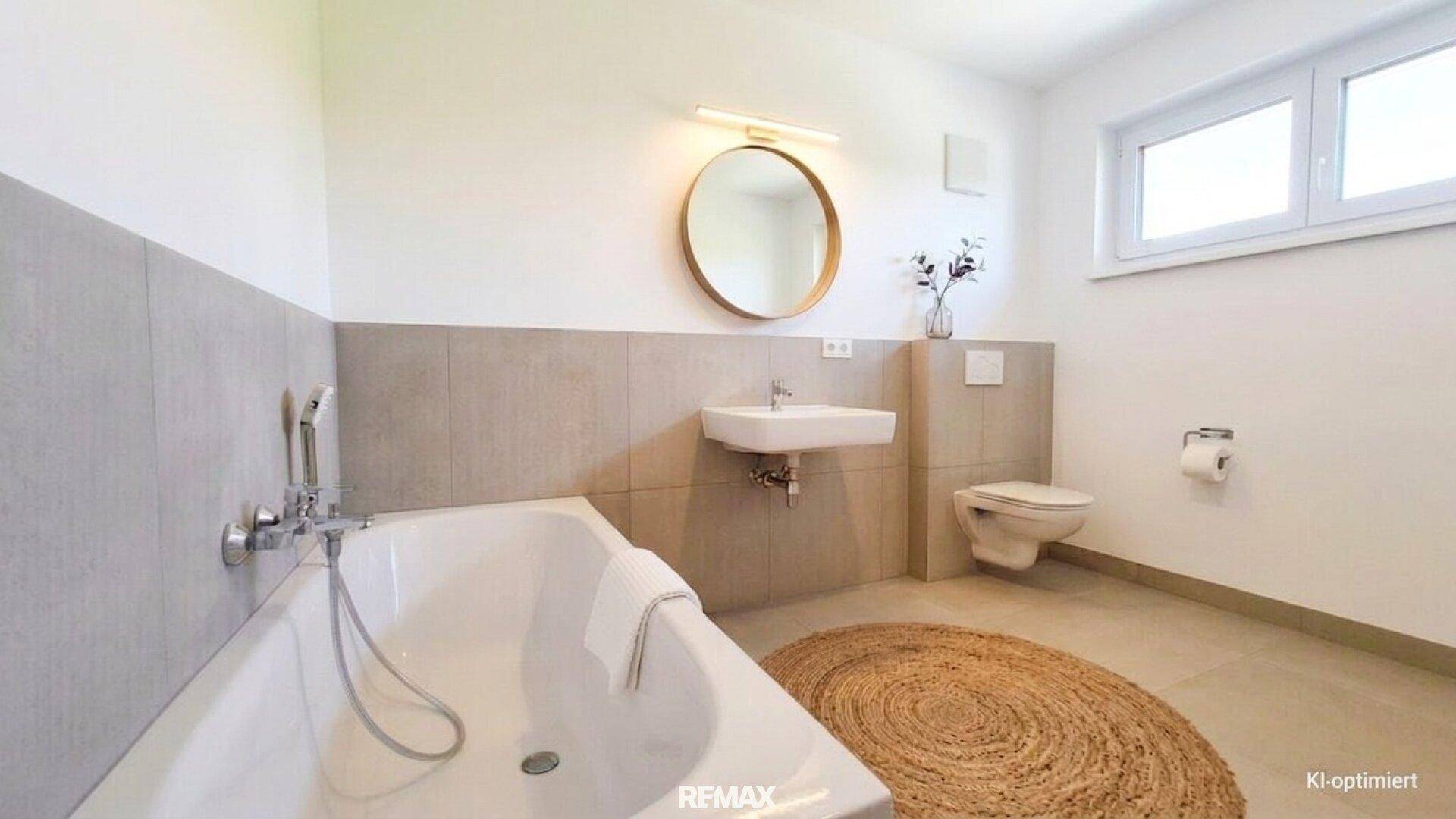 Modernes Badezimmer mit Badewanne, Wand-WC und Fenster.