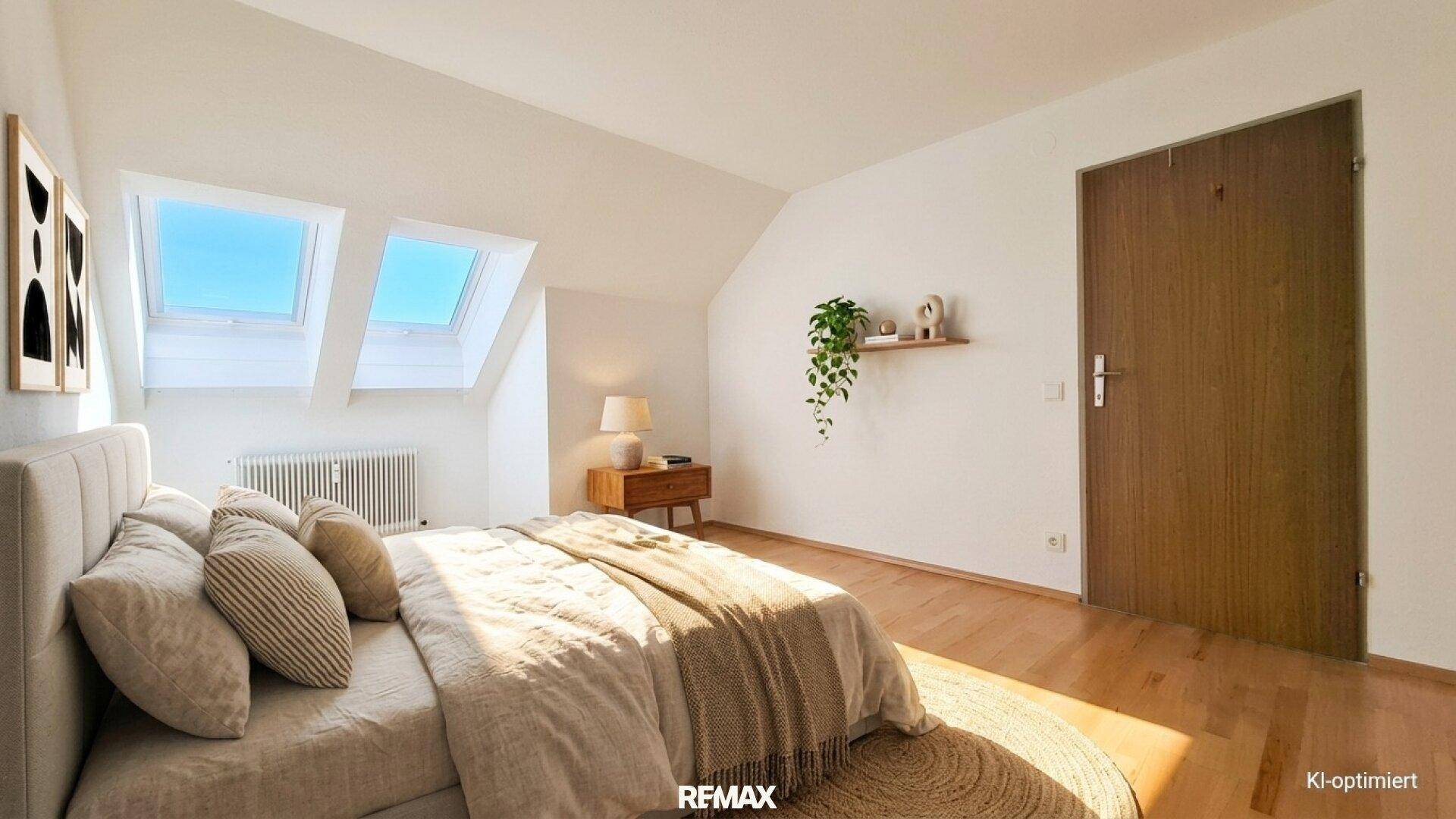 Gemütliches Schlafzimmer mit Dachschrägen, Dachfenstern und Holzboden im oberen Stockwerk.