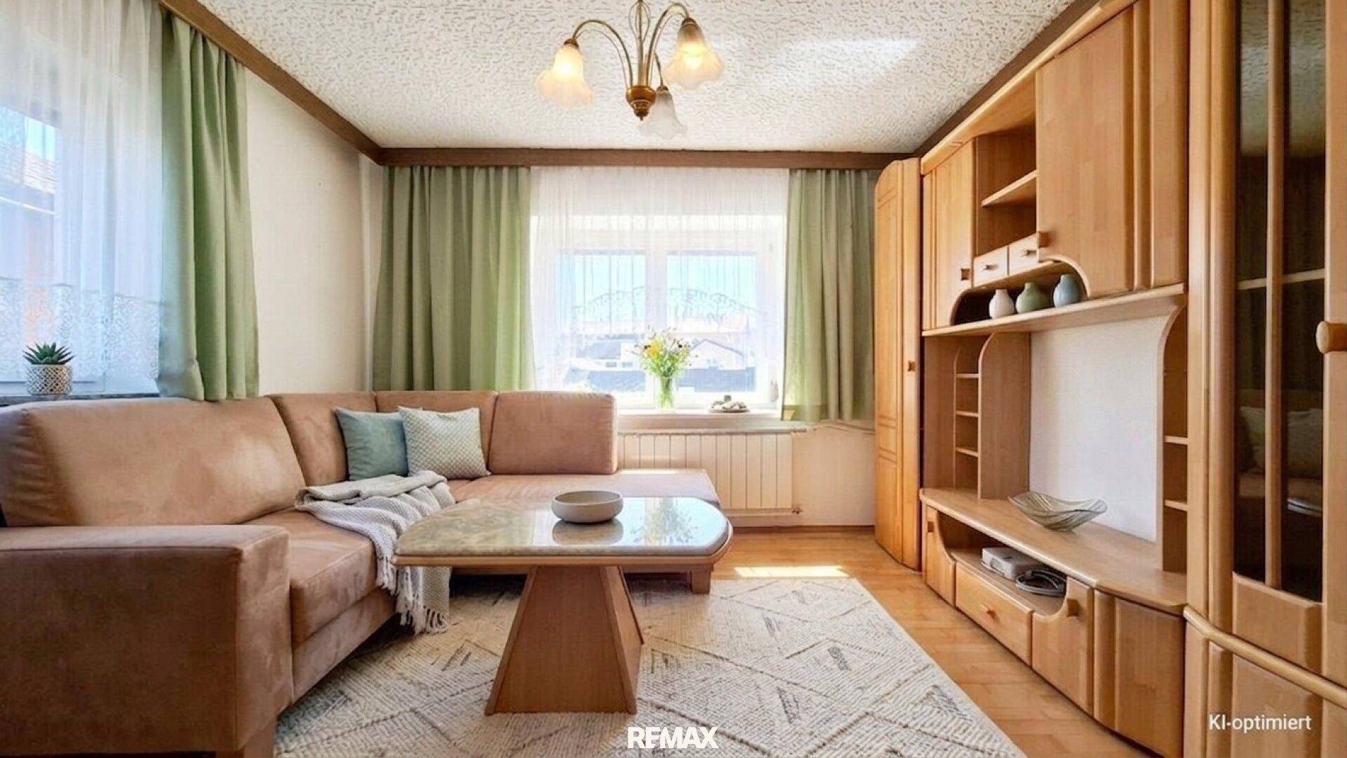 Wohnzimmer mit bequemer Couch, Holzmöbeln und Teppichboden.