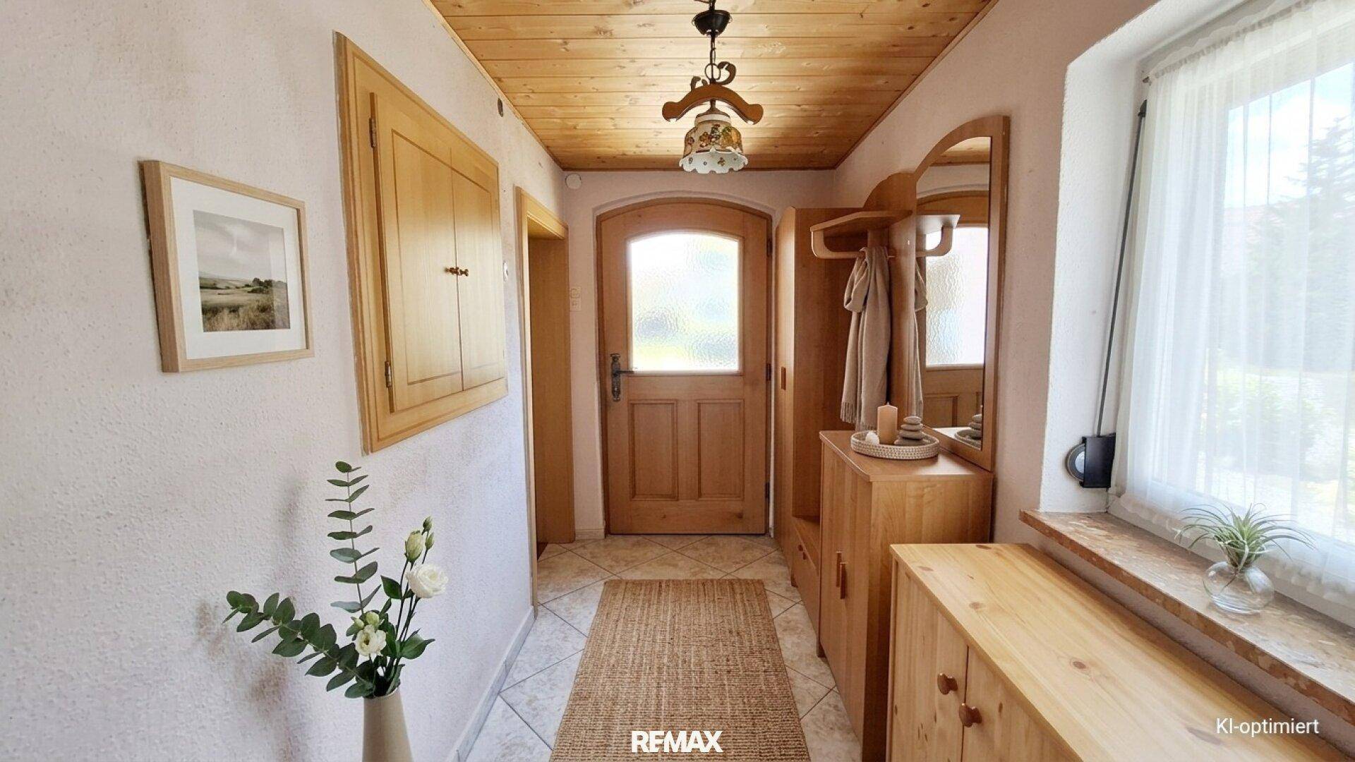 Eingangsbereich mit Holzdecke, Garderobe und Fenster.