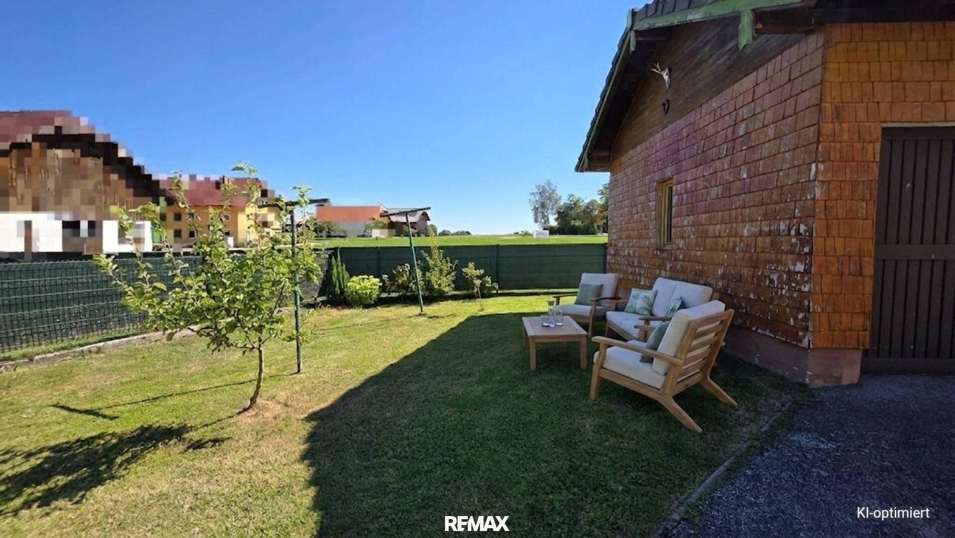 Gartenbereich mit Rasenfläche, jungen Bäumen und Sitzgelegenheiten.