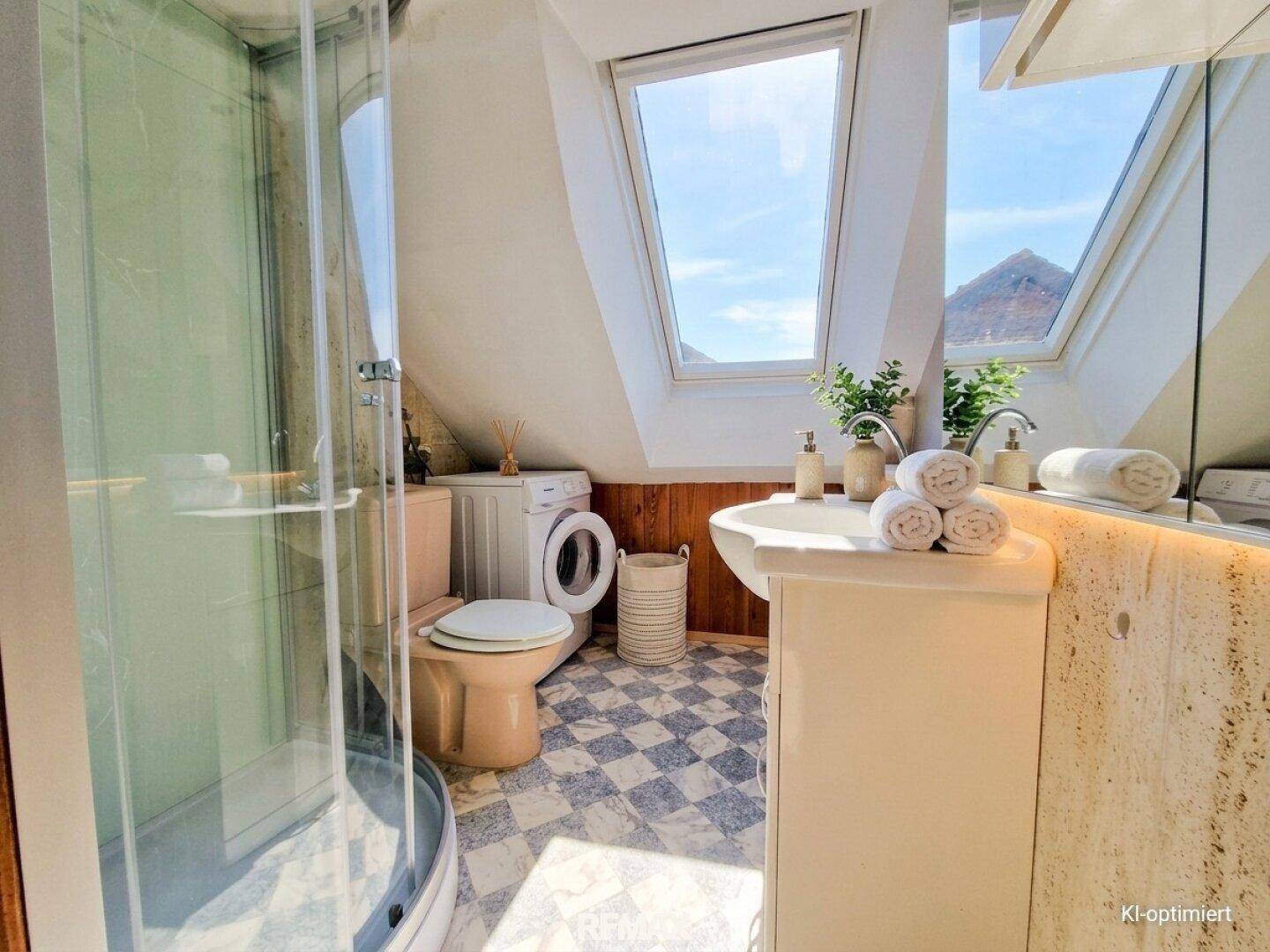 Badezimmer mit Duschkabine, Waschbecken, WC und Dachfenstern, die viel Tageslicht hereinlassen.