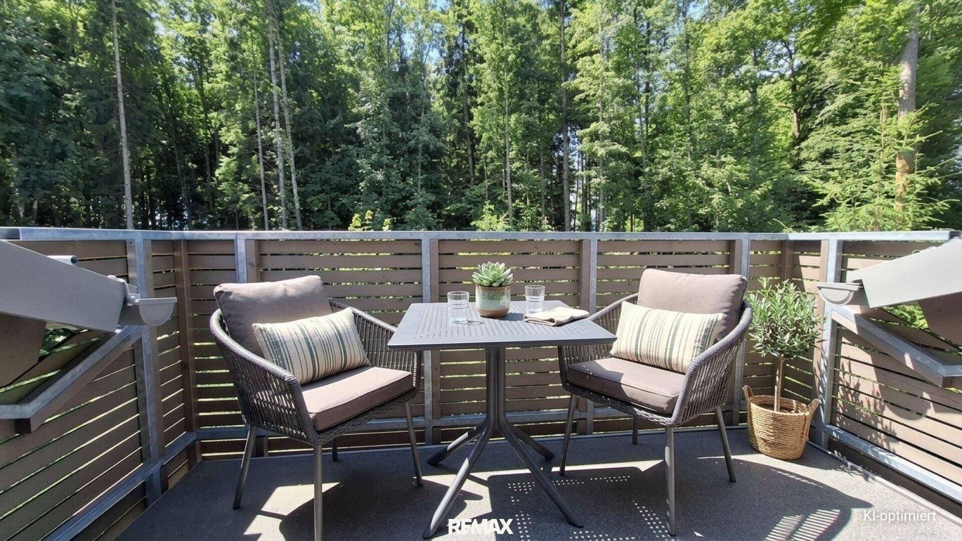 Sonniger Balkon mit modernen Sitzgelegenheiten und einem schönen Blick ins Grüne.