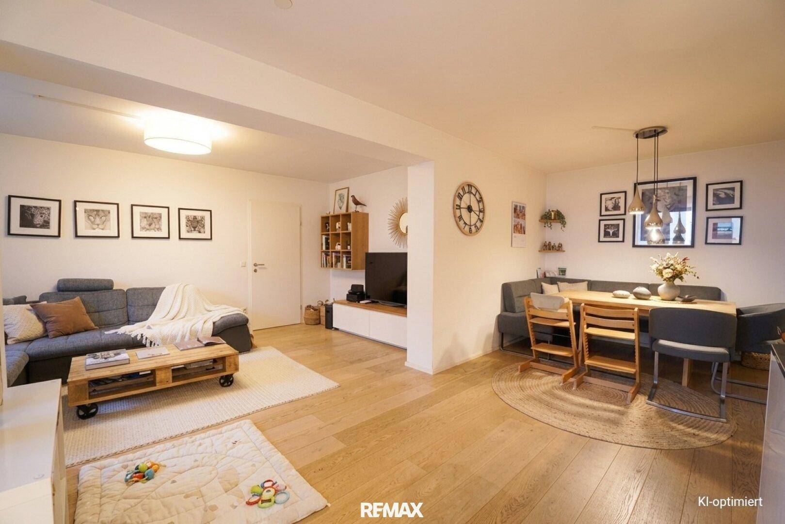 Geräumiger Wohn- und Essbereich mit Holzboden, Sofa und Esstisch, ideal für geselliges Beisammensein.