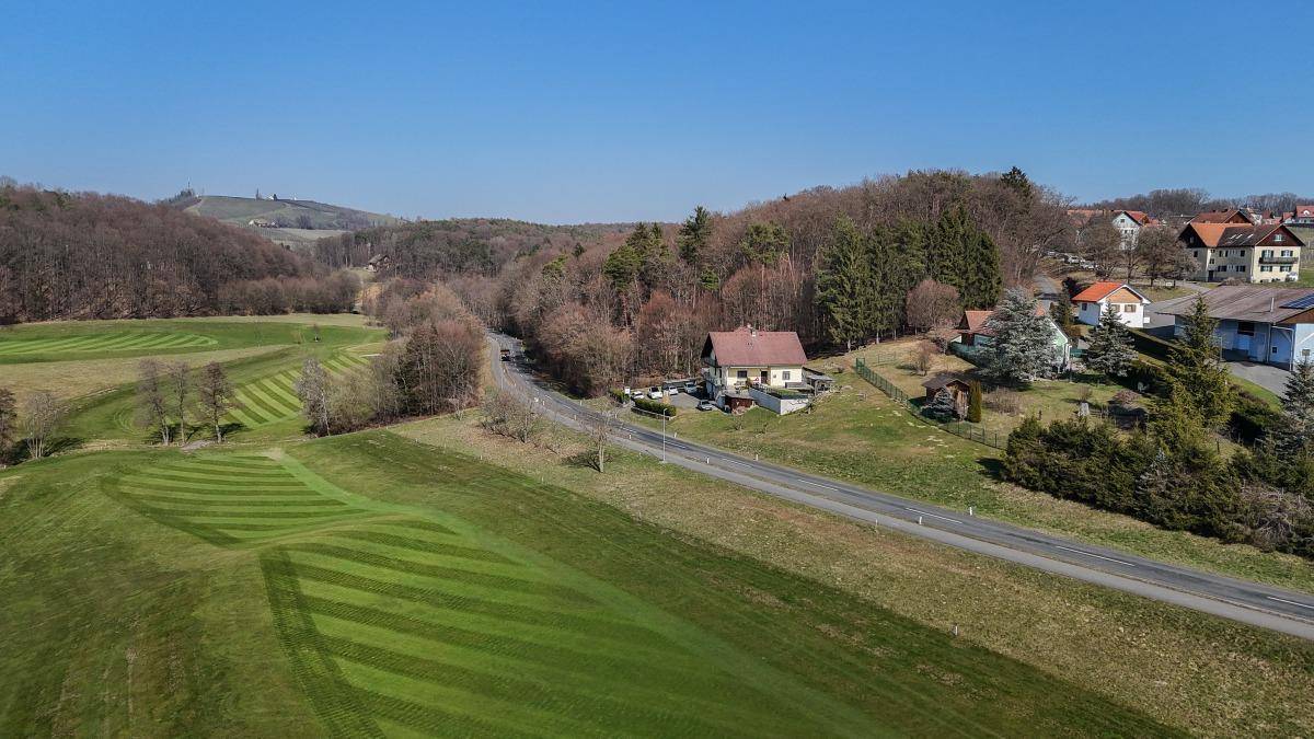 Weitläufige Luftaufnahme der Immobilie in einer idyllischen ländlichen Umgebung mit Feldern und Wald.