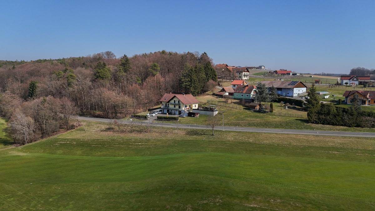 Panoramablick aus der Luft auf das Anwesen, eingebettet in eine grüne Hügellandschaft.