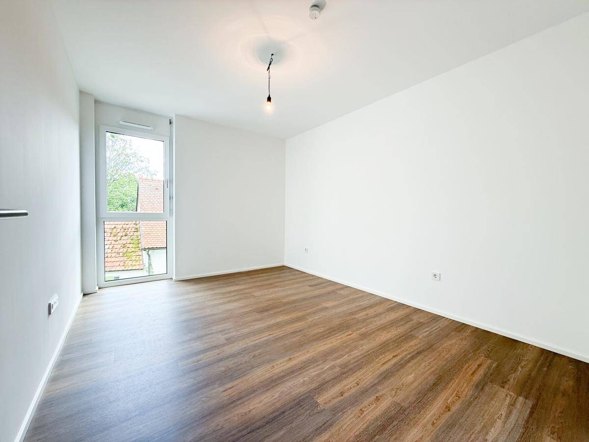 Geräumiges Schlafzimmer mit Laminatboden und Fenster, bereit zur individuellen Gestaltung.