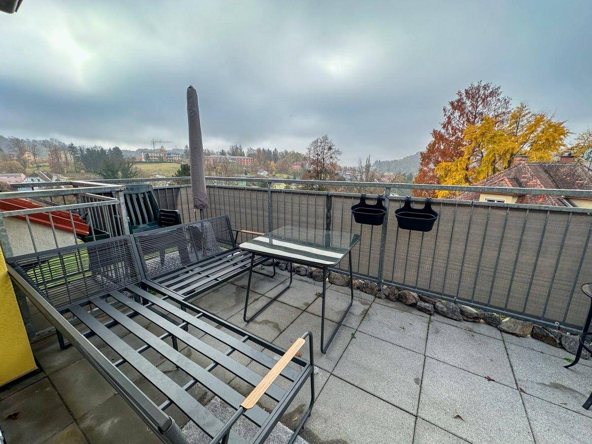 Geräumiger Balkon mit Sitzgelegenheiten und Blick auf die umliegende Natur.
