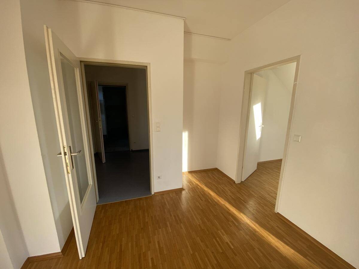 Heller Flurbereich mit Holzboden und mehreren Türen, die zu den angrenzenden Zimmern führen.