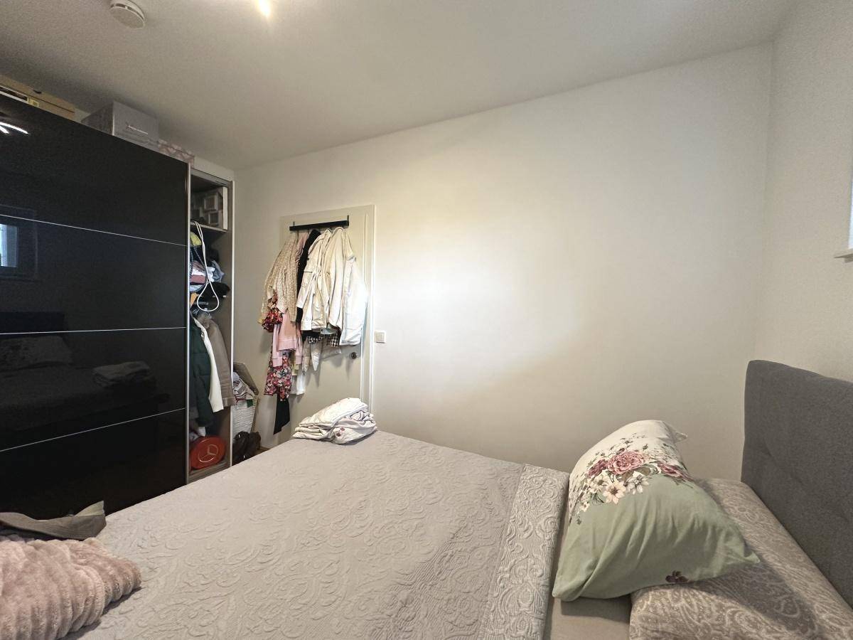Schlafzimmer mit großem schwarzen Kleiderschrank und gemütlichem Bett, bietet viel Stauraum.