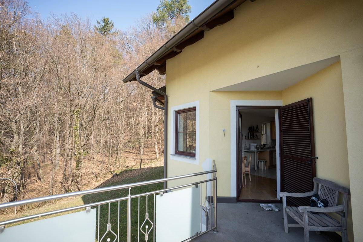 Balkon mit Sitzbank und Blick auf den angrenzenden Wald, ideal zum Entspannen.