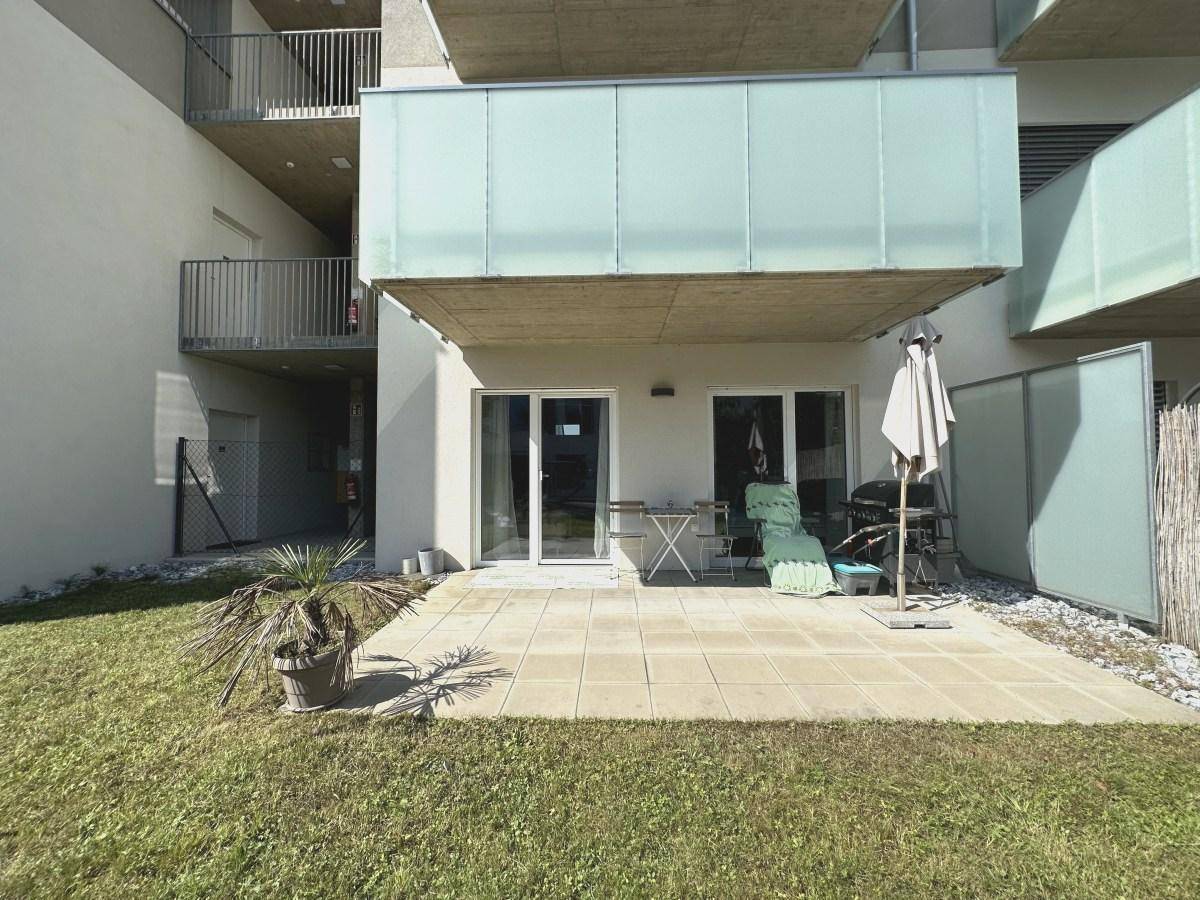 Große, geflieste Terrasse mit Gartenmöbeln und direktem Zugang zum privaten Garten.