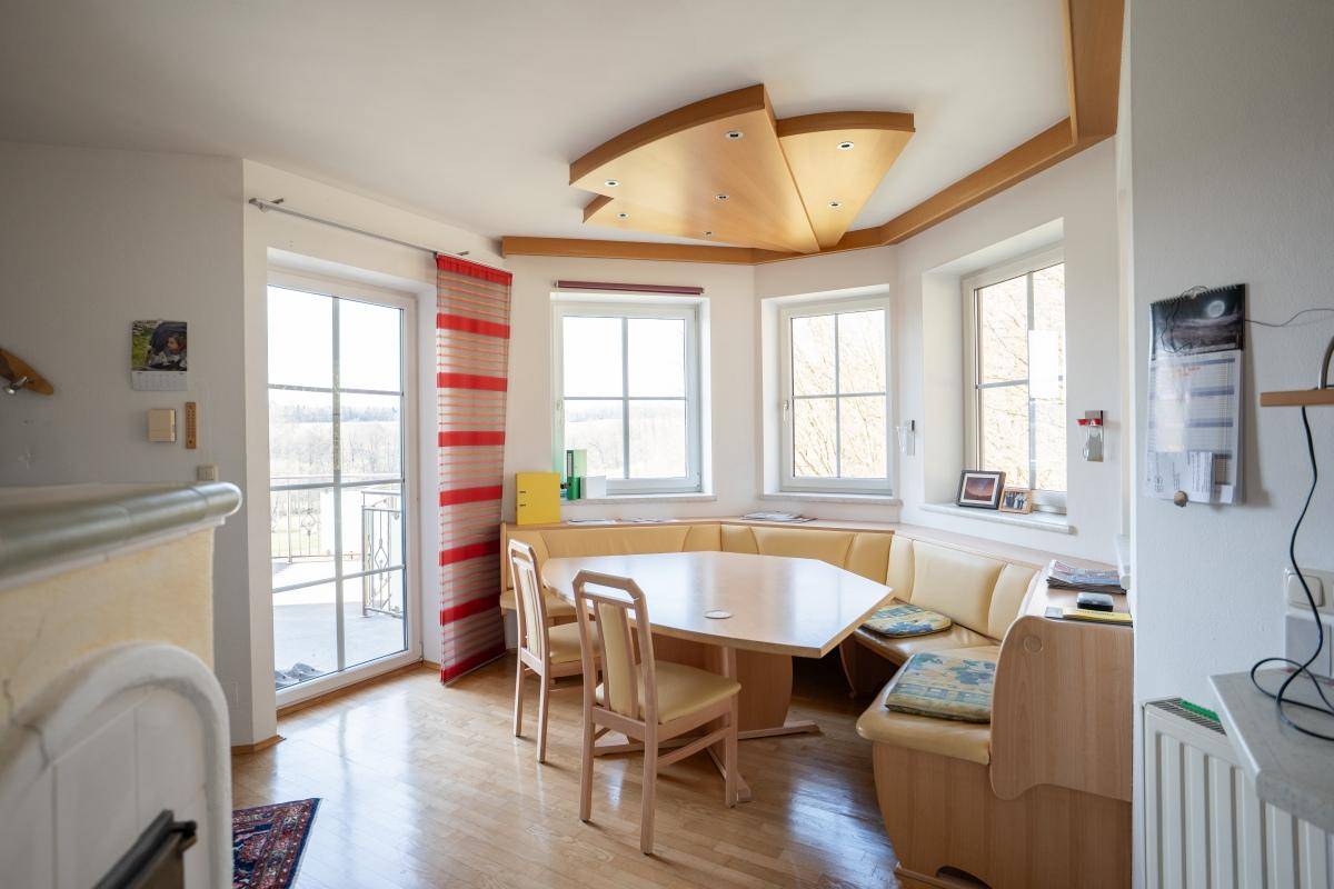 Gemütlicher Essbereich mit Eckbank, Holztisch und Zugang zu einem Balkon mit Weitblick.