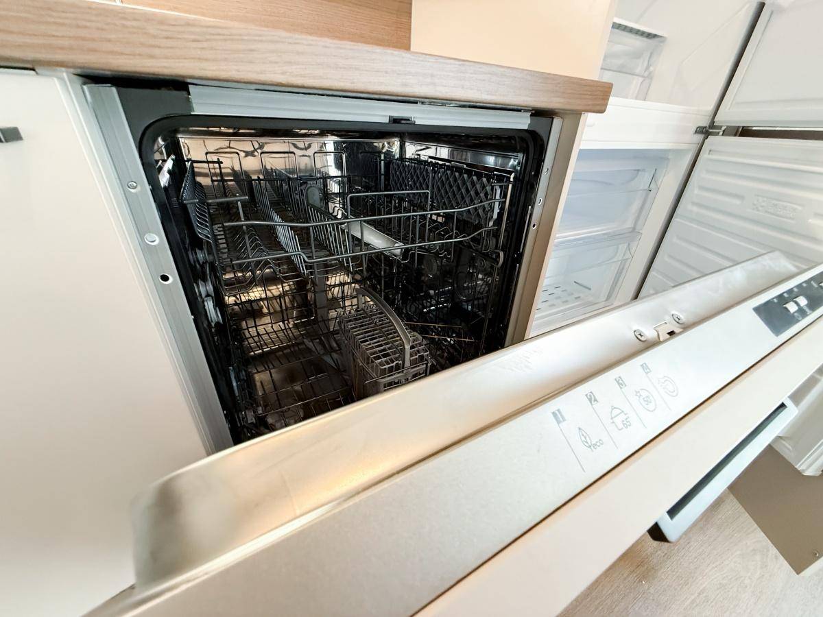 Integrierter Geschirrspüler in einer modernen Küche mit Holzoptik-Arbeitsplatte.