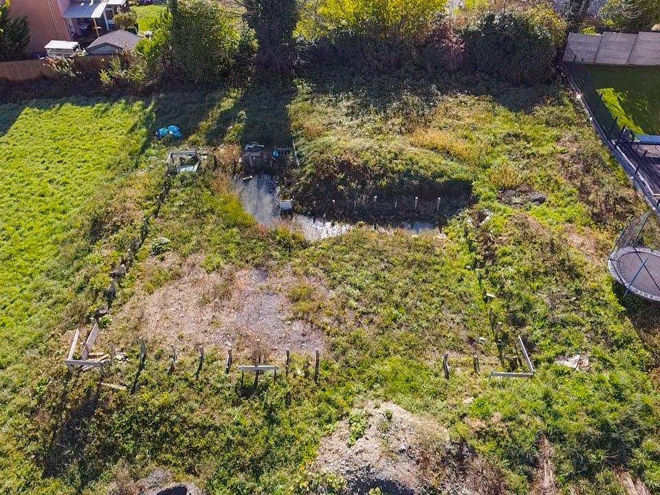 Übersicht des Grundstücks aus der Vogelperspektive mit verwilderten Bereichen, einem kleinen Teich und einem Trampolin.