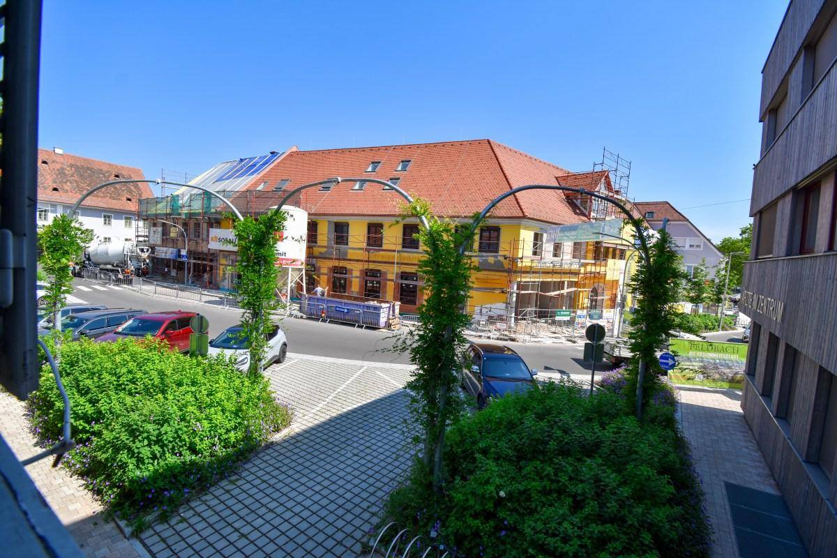 Blick von oben auf die Straße mit parkenden Autos und einem Gebäude im Umbau.
