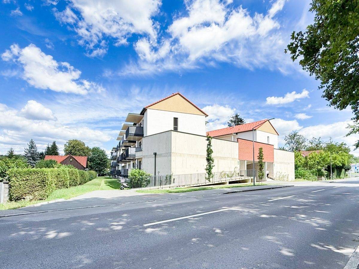 Weitläufige Straßenansicht des Neubaukomplexes, der sich harmonisch in die Umgebung einfügt.