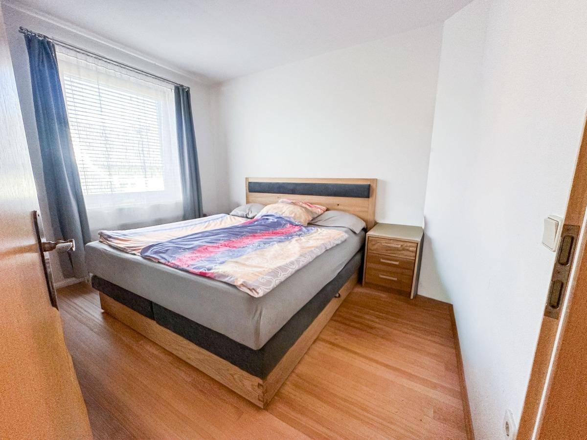 Gemütliches Schlafzimmer mit Doppelbett, Nachttisch und Holzfußboden.