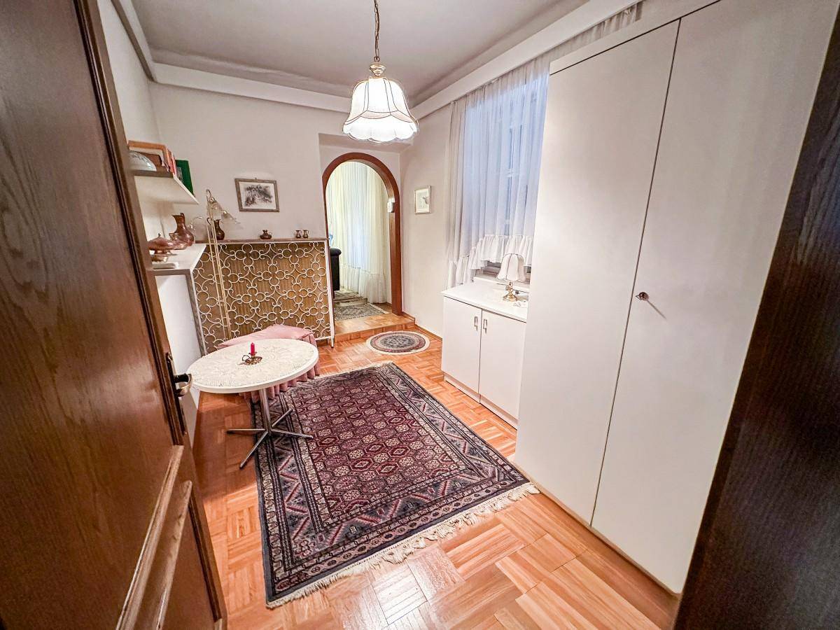 Kleines Zimmer mit Parkettboden, weißem Schrank und Teppich.